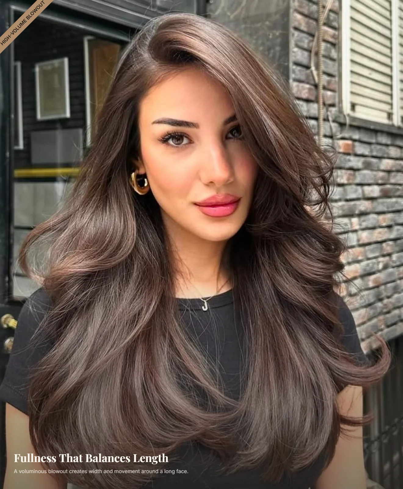 Woman with a long face wearing a voluminous blowout with soft waves and fullness at the sides