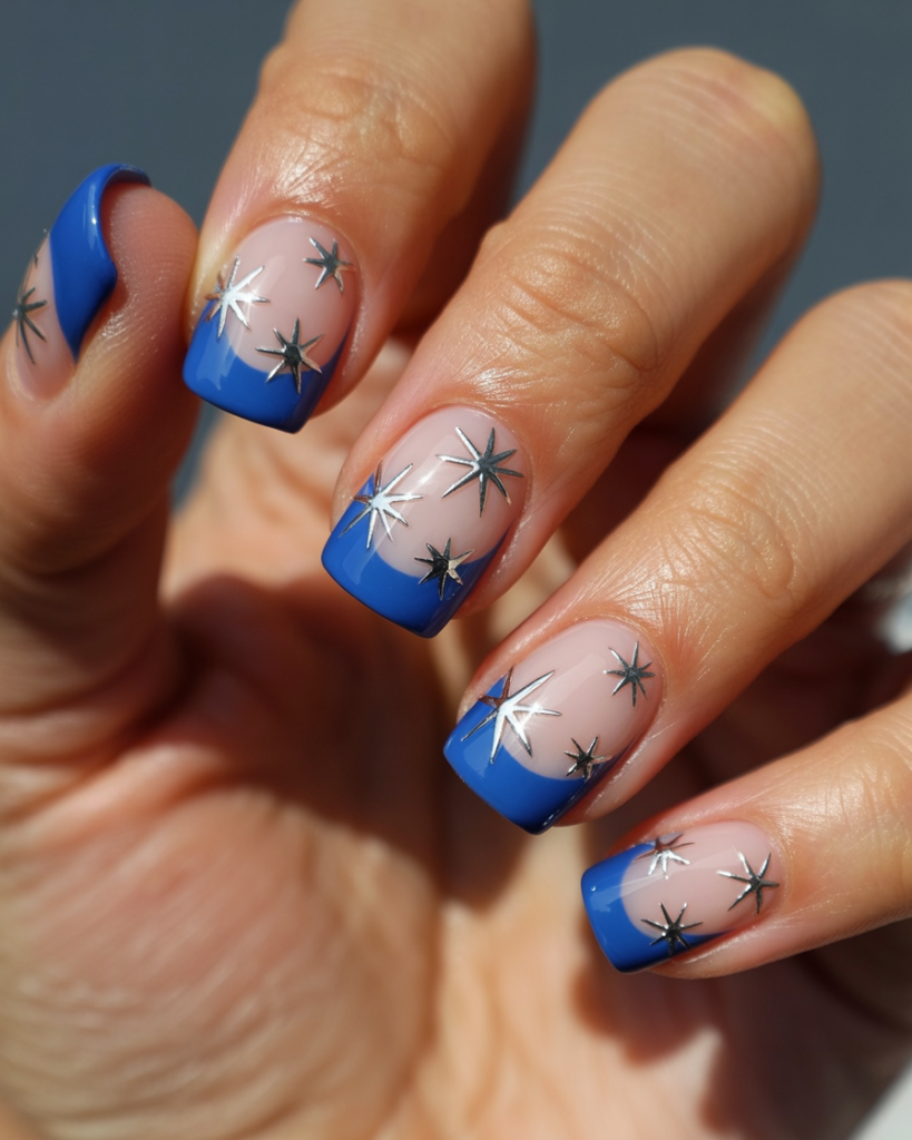 Nude square nails with glossy blue French tips and silver stars for a patriotic manicure.