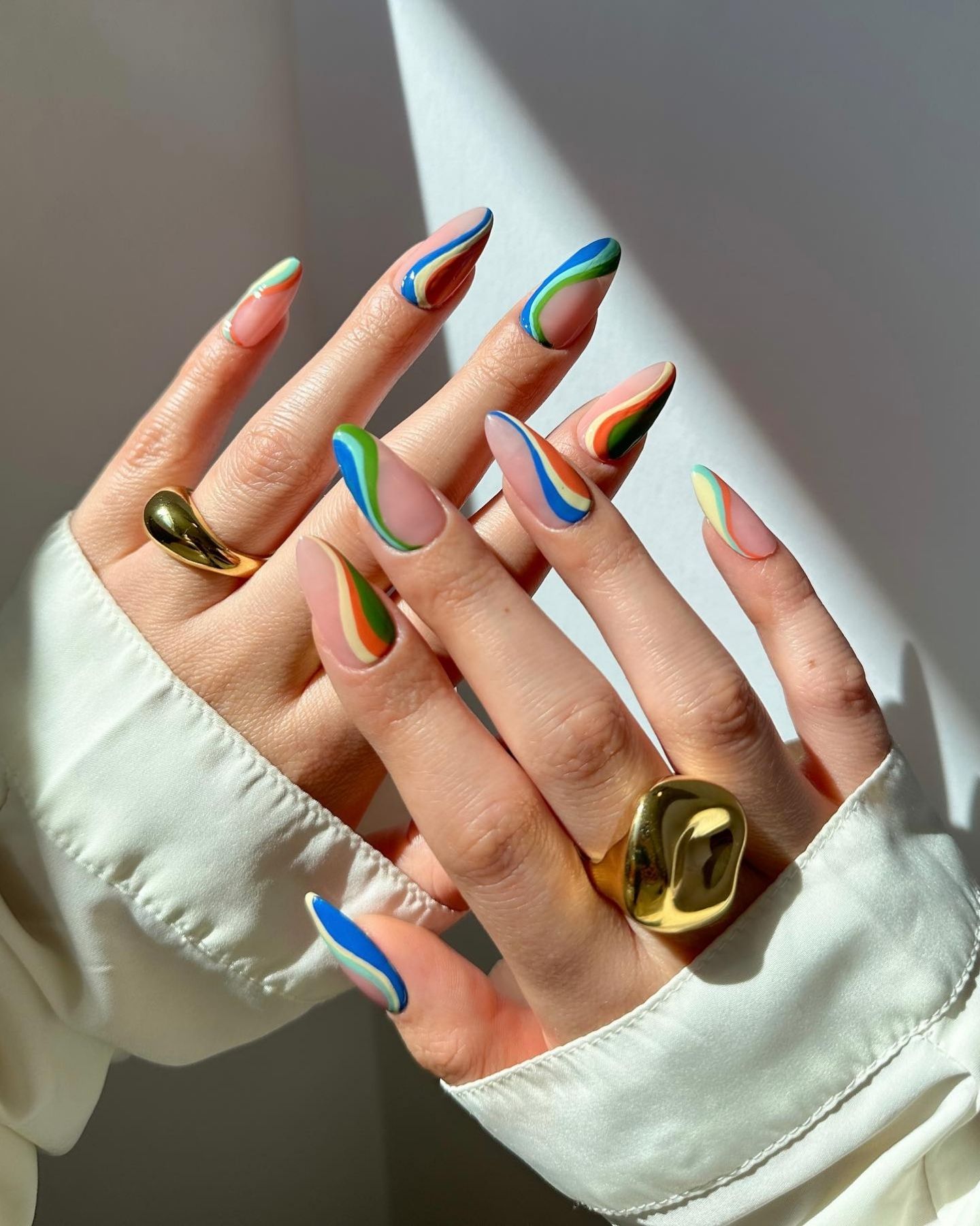 Colorful glitter swirl rainbow nail design with bold colors and a glamorous, playful finish