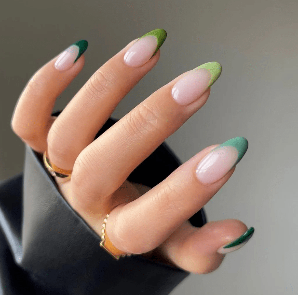 Long, almond nails featuring a smooth green ombré effect that fades from a soft mint hue to a deeper forest green.