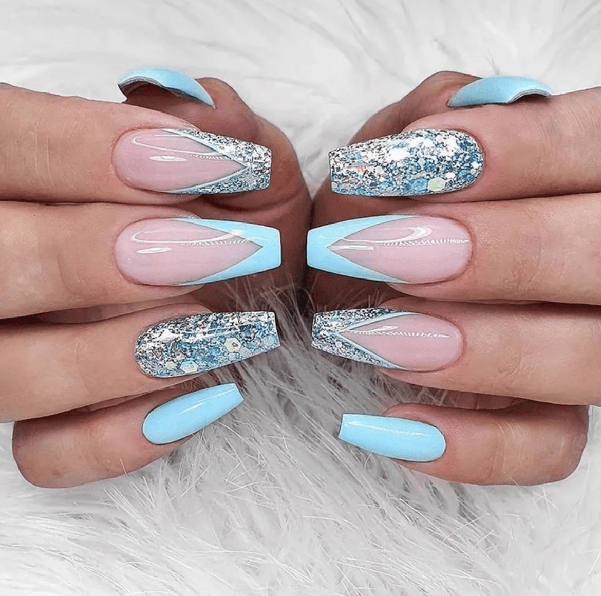 Long stiletto nails with light blue polish and silver glitter chevron designs on tips with two accent nails in translucent pink and clear outlined in silver glitter