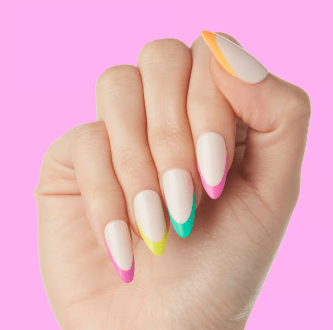 Almond-shaped nails with matte white polish and multicolored French tips, set against a pink background, featuring orange accent lines on thumb and index