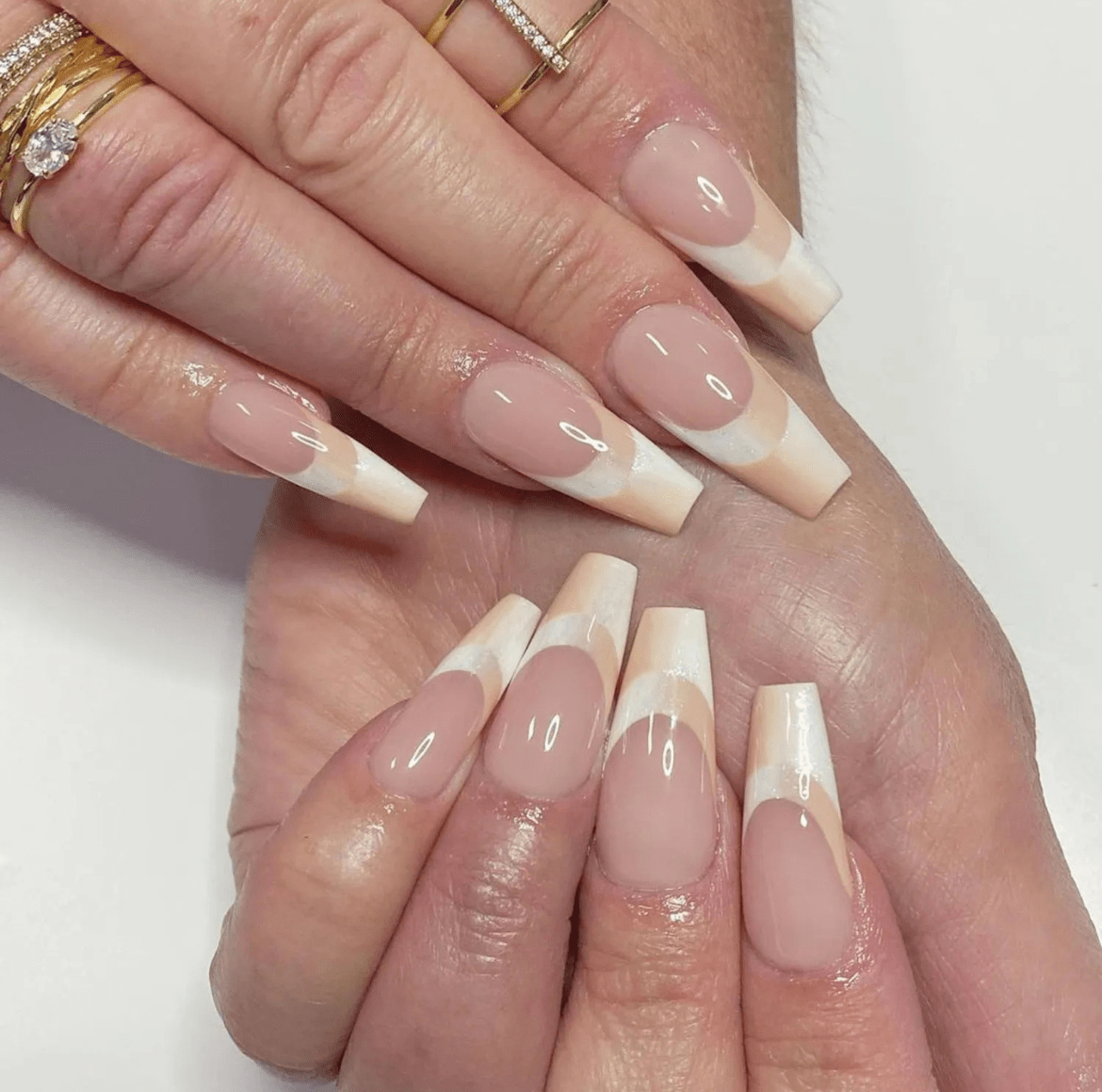 Nails with a creamy neutral double ombré French tip design, featuring soft, blended colors that highlight a subtle, elegant look.