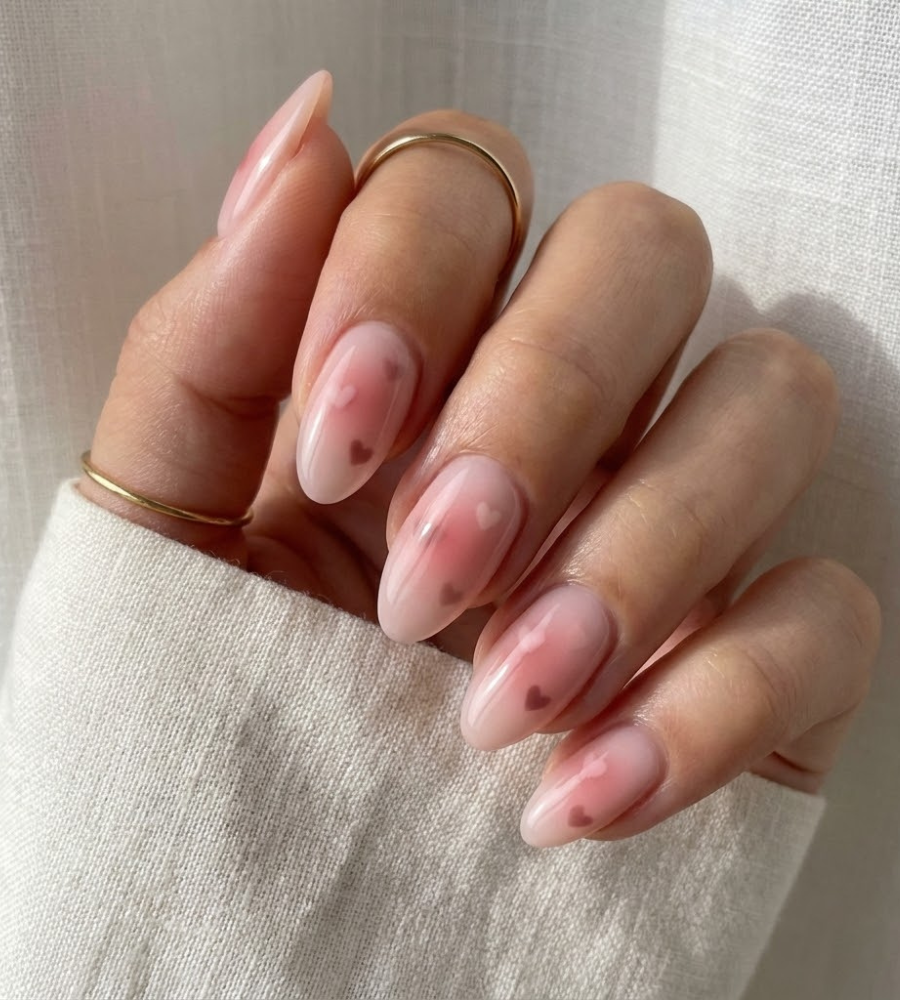 Pink aura heart nails with soft blush glow and glossy almond shape