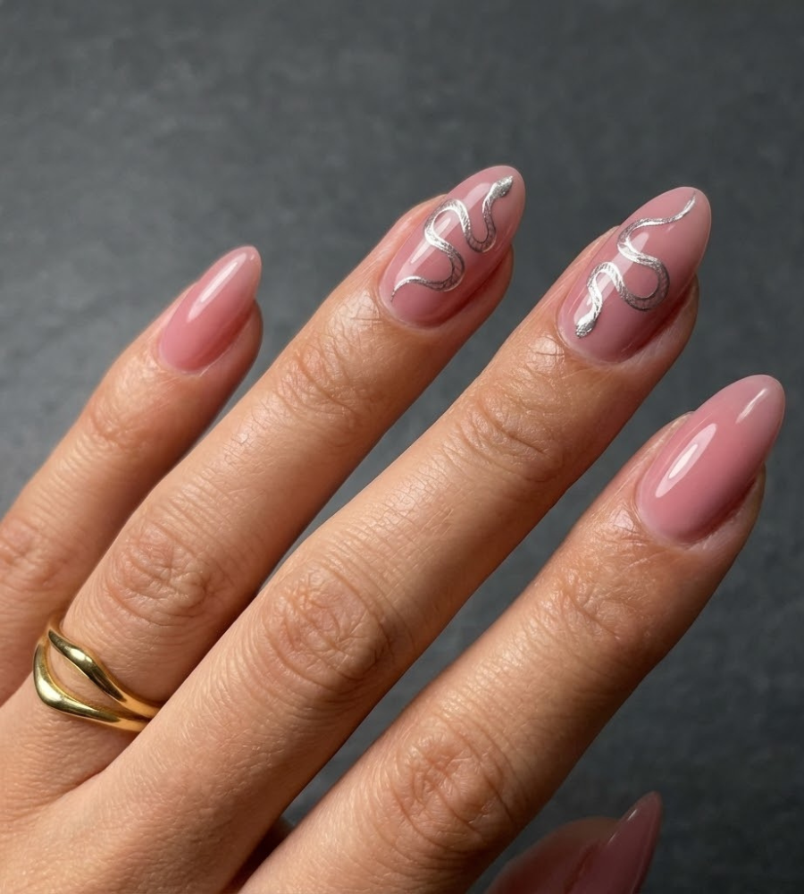 Pink serpent nails with metallic line art on almond shape