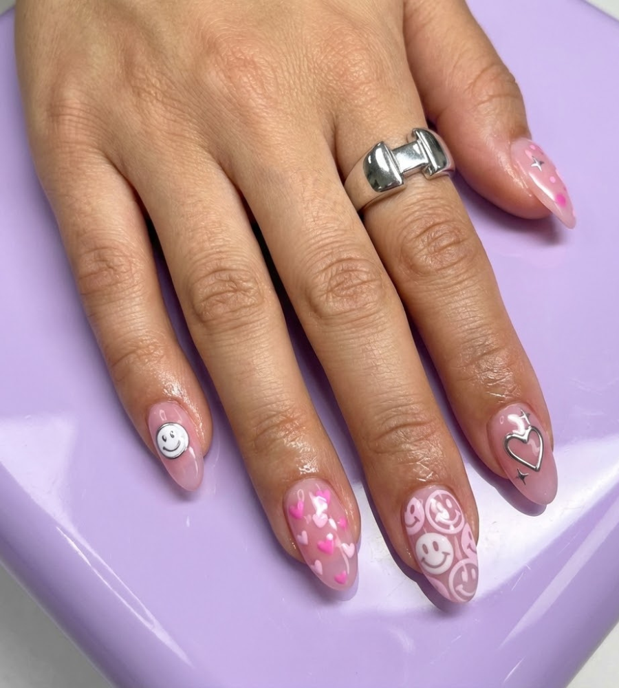 Y2K pink nail design with playful icons and glossy almond shape
