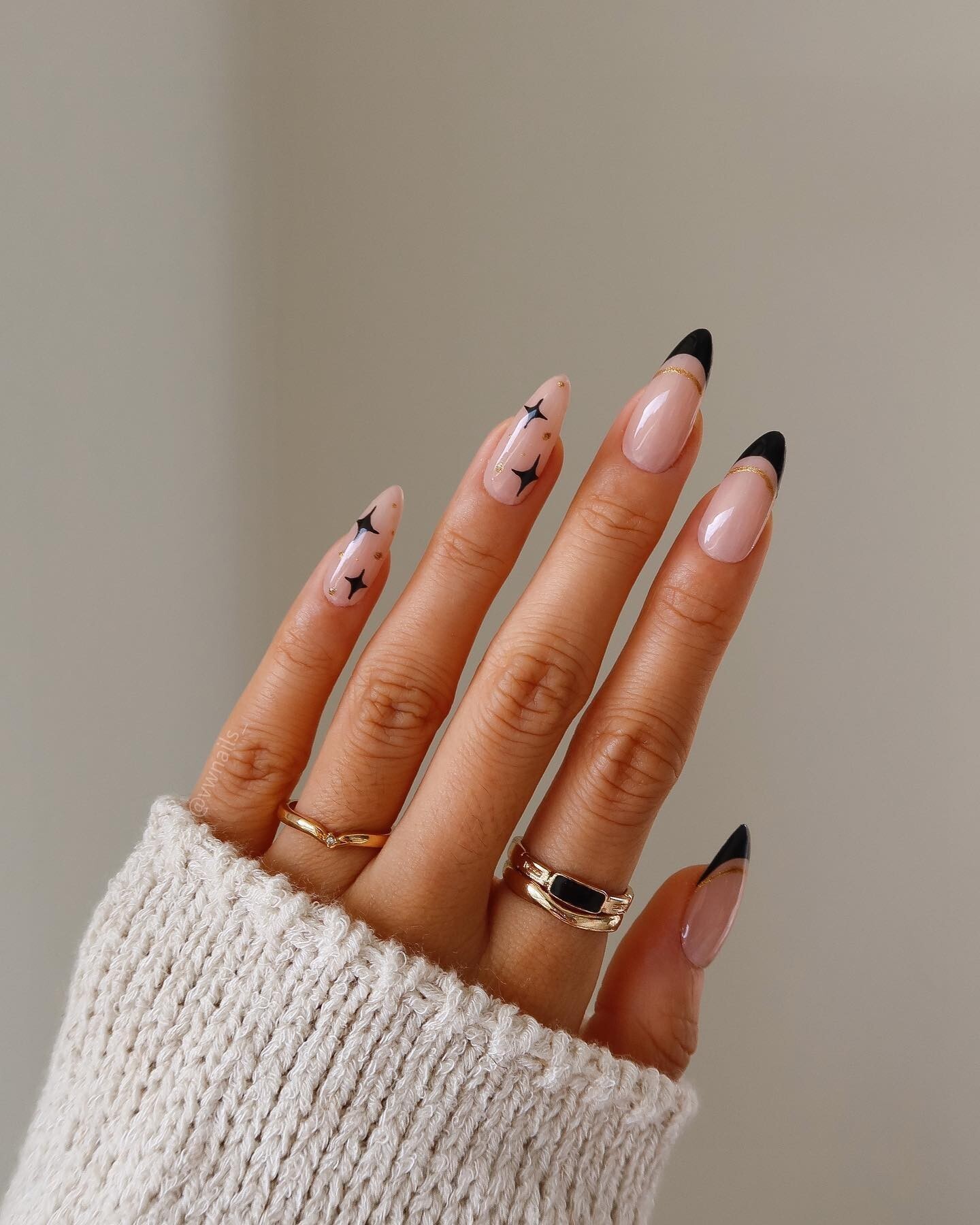 silver French tip nails and scattered black star nail art over a nude base
