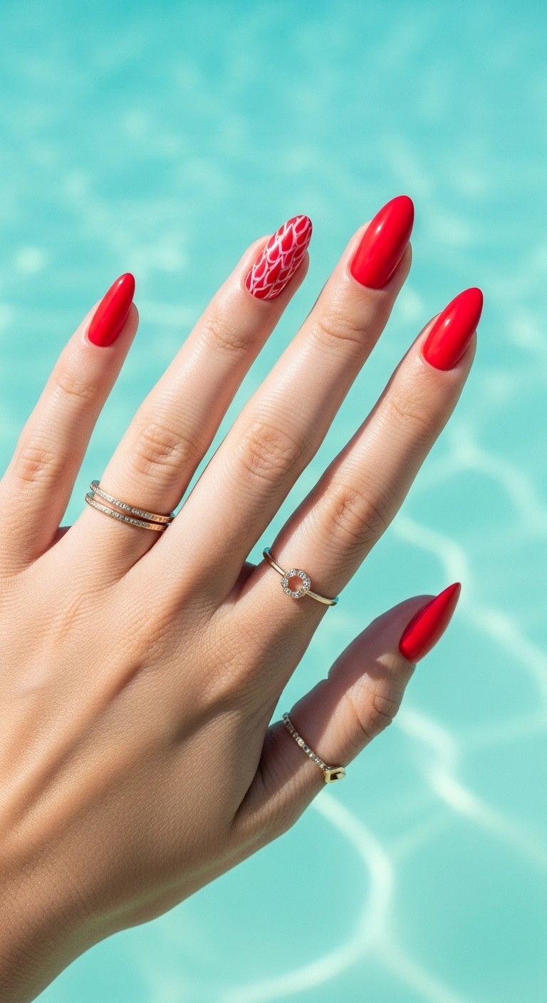 A woman’s hand with glossy, fiery red Hawaii-inspired nails featuring hand-painted tropical designs, framed by gold rings and set against a soft-focus mint blue Hawaiian beach.