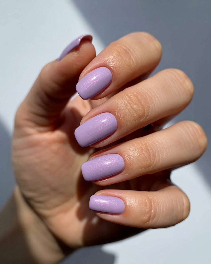 Glossy soft lilac nails with subtle shimmer, perfect for a trendy summer manicure.