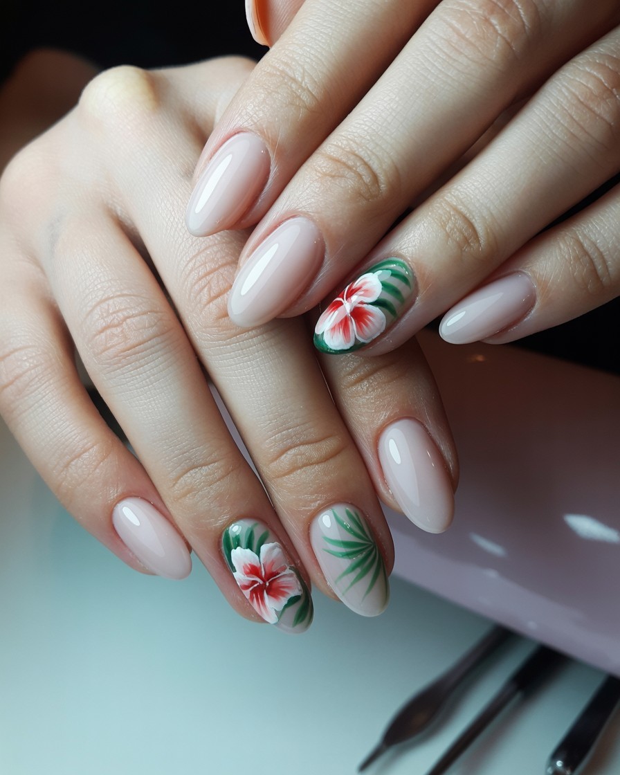 Glossy almond nails with delicate tropical floral designs as accent nails in a professional salon setting.