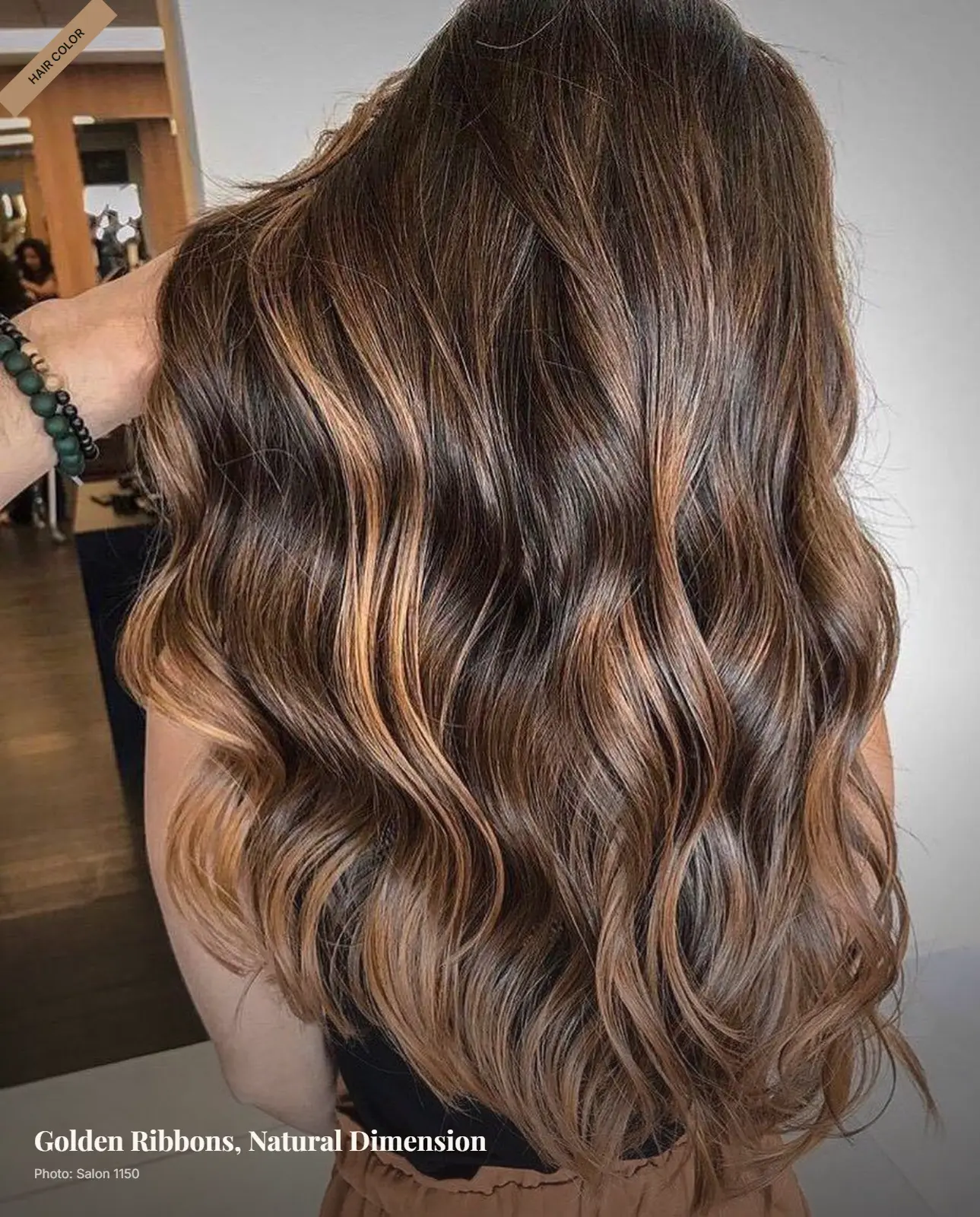 Brown hair with hand-painted golden caramel balayage highlights styled in soft waves
