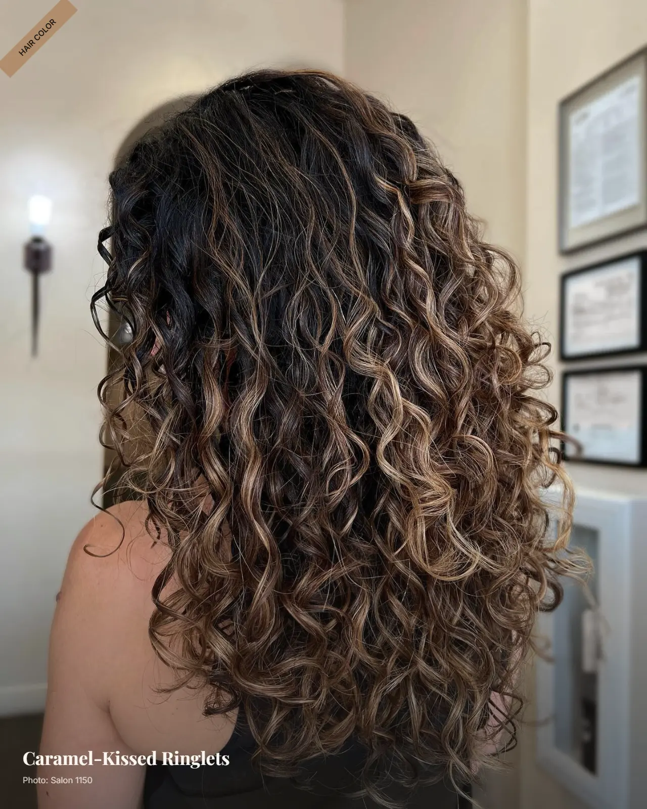 Brunette hair with soft caramel balayage woven through defined loose ringlets