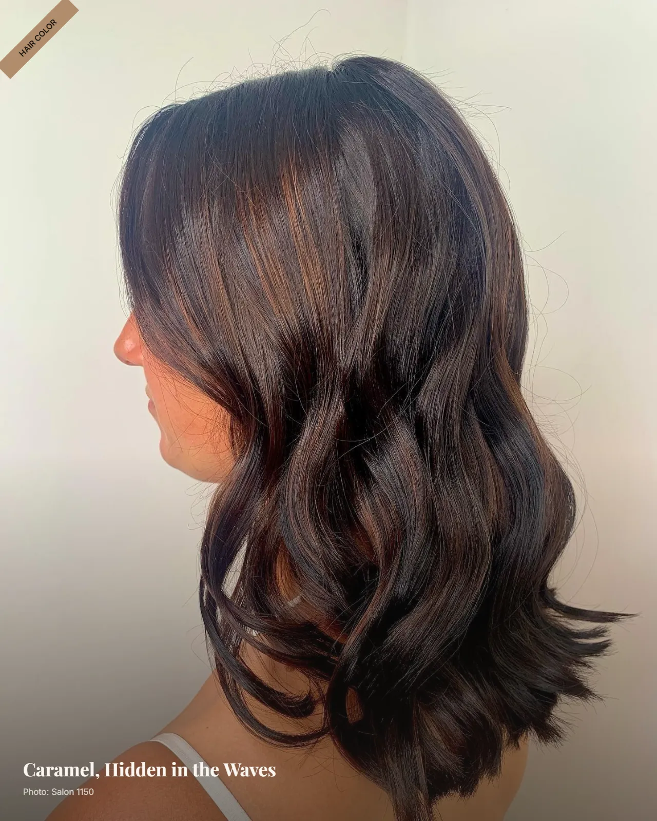 Dark brunette hair with subtle caramel peek-a-boo highlights visible beneath soft waves