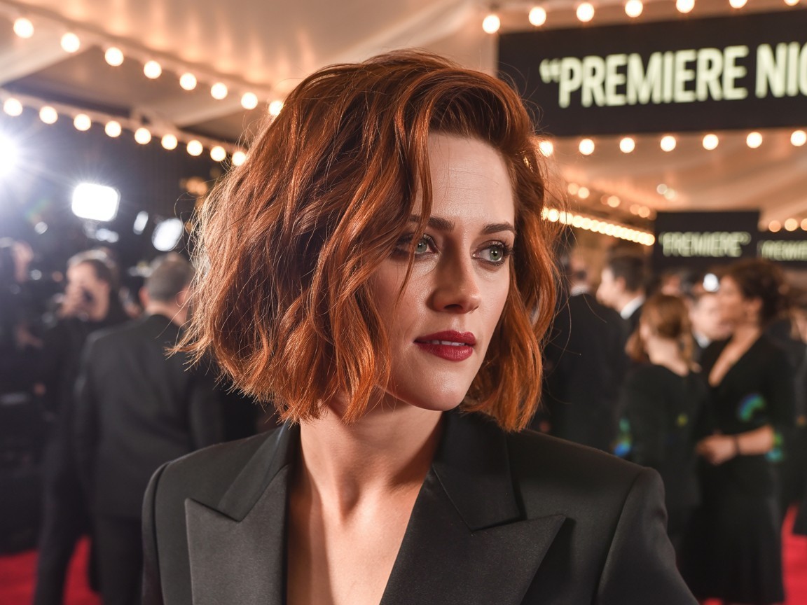Kristen Stewart with a textured bob and copper balayage, featuring tousled waves and glowing copper highlights at a fashion-forward red carpet event.