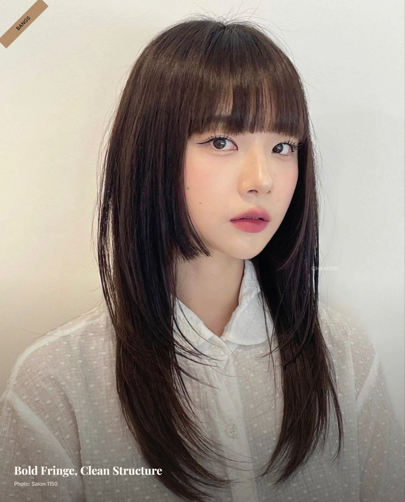 Sleek straight hair with bold blunt bangs framing a round face