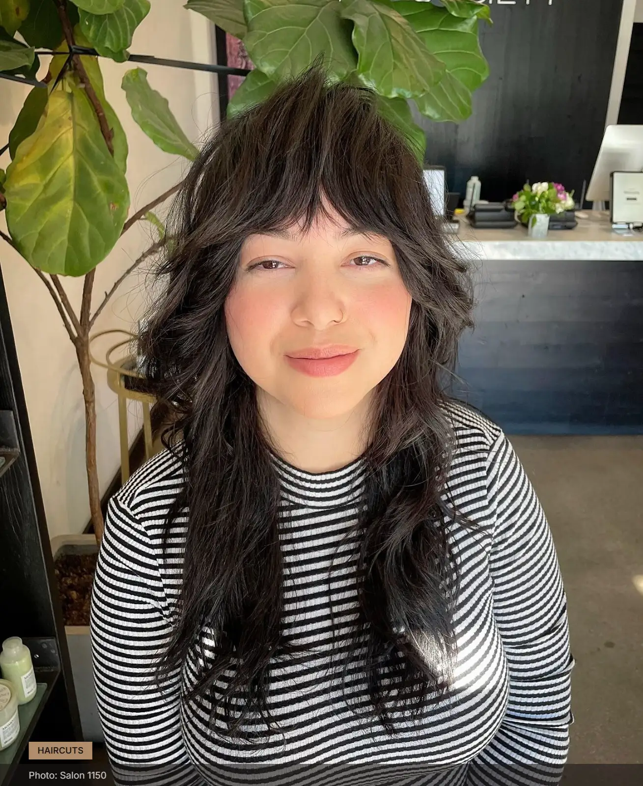 Tousled shag haircut with textured layers and short fringe framing a round face