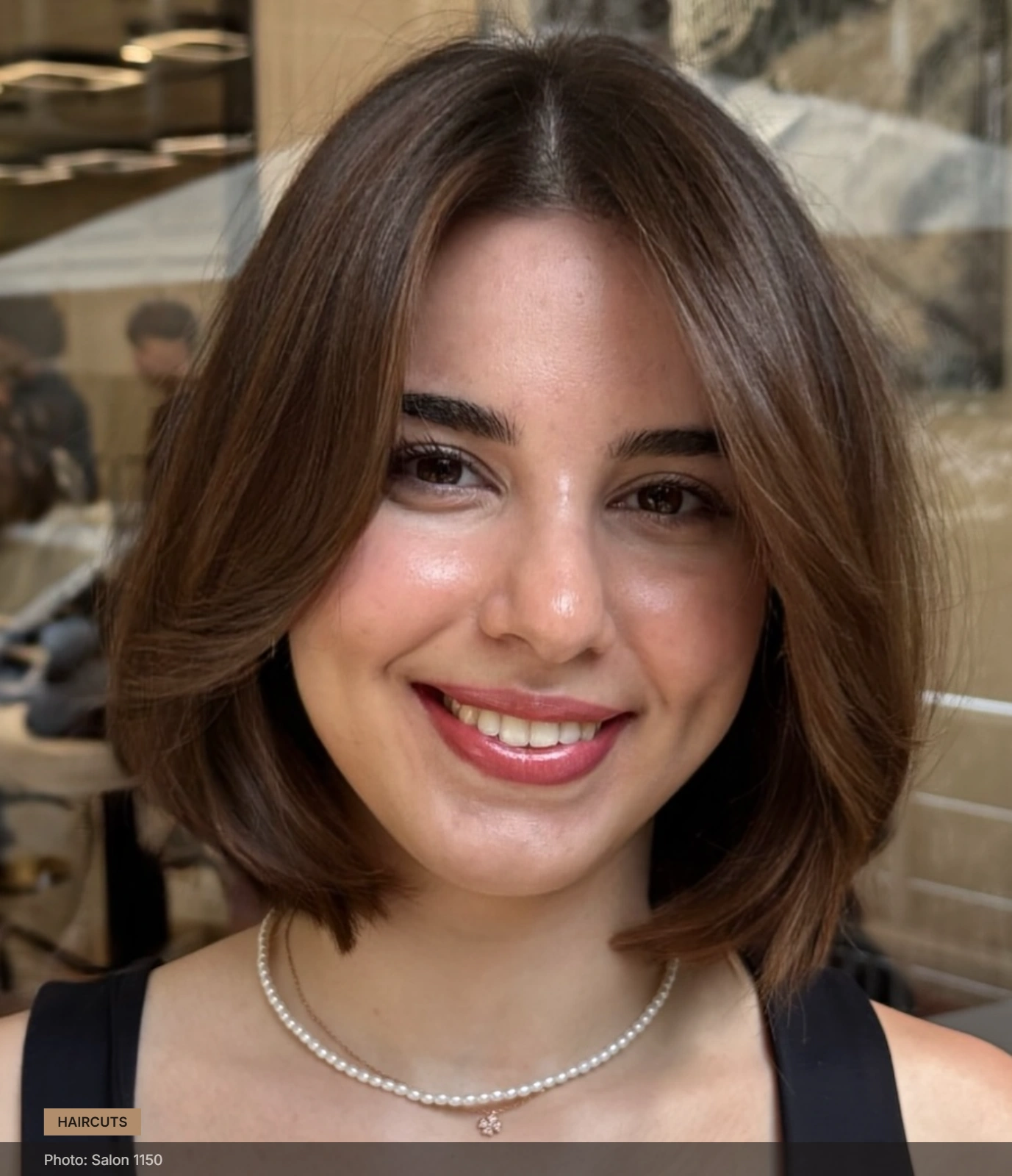 Short textured bob with center part, soft waves and lightly layered ends framing a round face