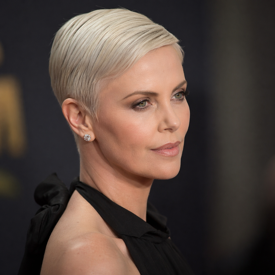 Charlize Theron sleek platinum pixie short haircut with smooth texture and red carpet styling