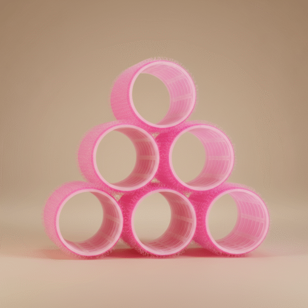 Stacked pink Velcro hair rollers arranged in pyramid shape for heatless curling