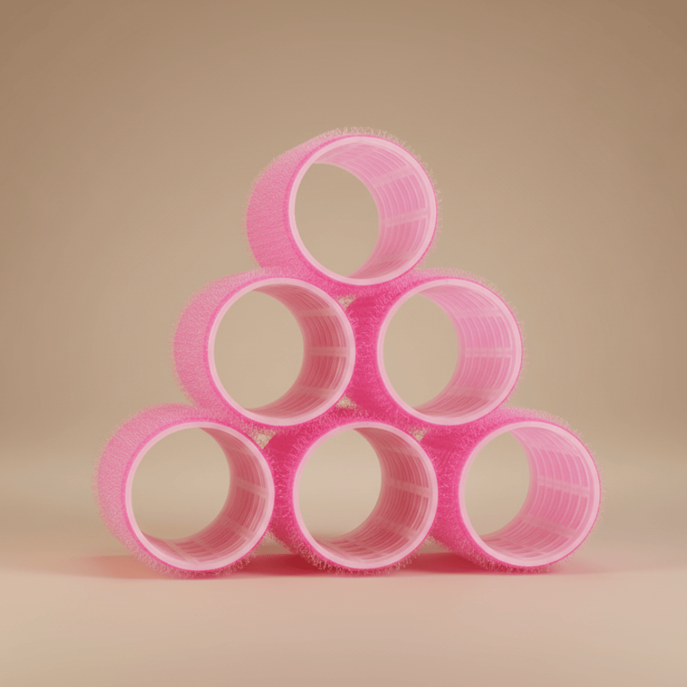 Stacked pink Velcro hair rollers arranged in pyramid shape for heatless curling