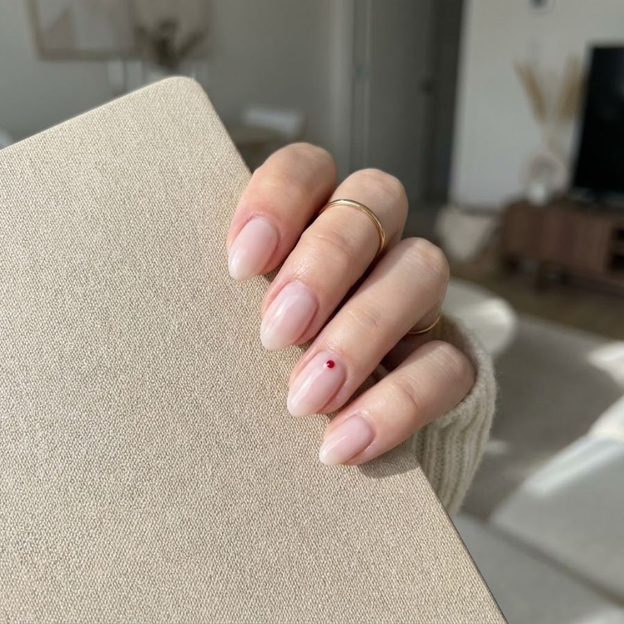 Minimalist Christmas nail with a sheer nude base and a subtle festive accent