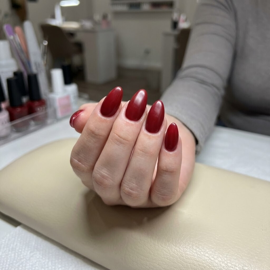Acrylic Christmas nail with a smooth structured finish, styled in a festive holiday color