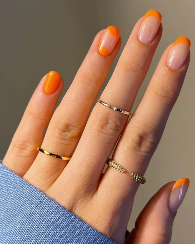 Squoval nails with orange French tip manicure showing square oval shape on natural-length nails