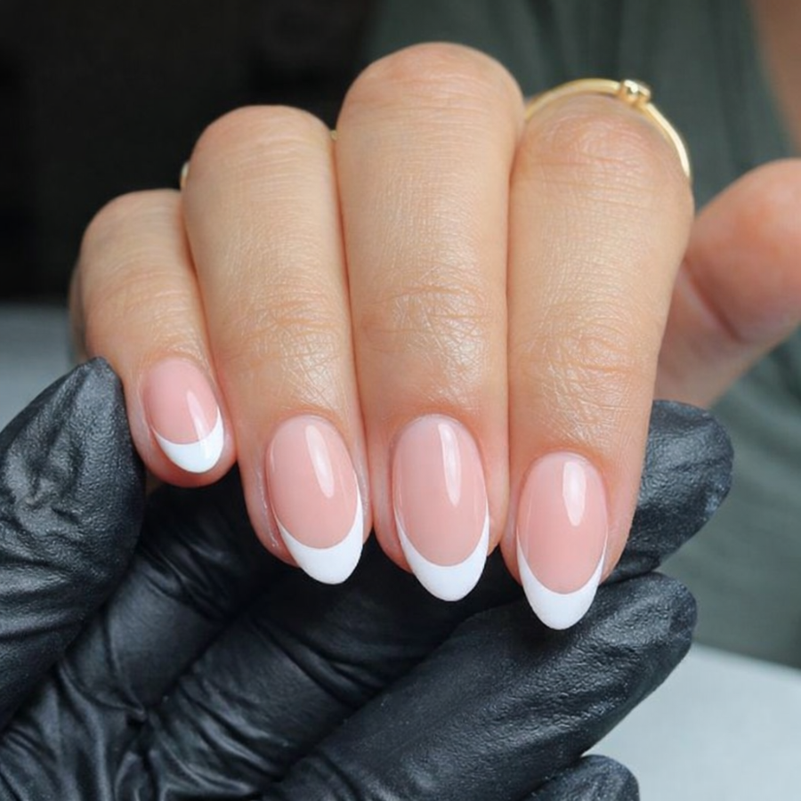 Almond french tip nails with classic white tips showing a tapered shape and curved tip line on a nude base