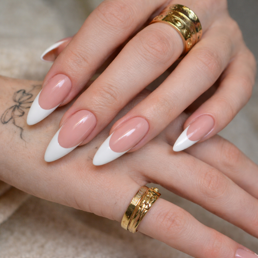 Deep french tip nails with wide white tips on almond shaped nails and a nude base