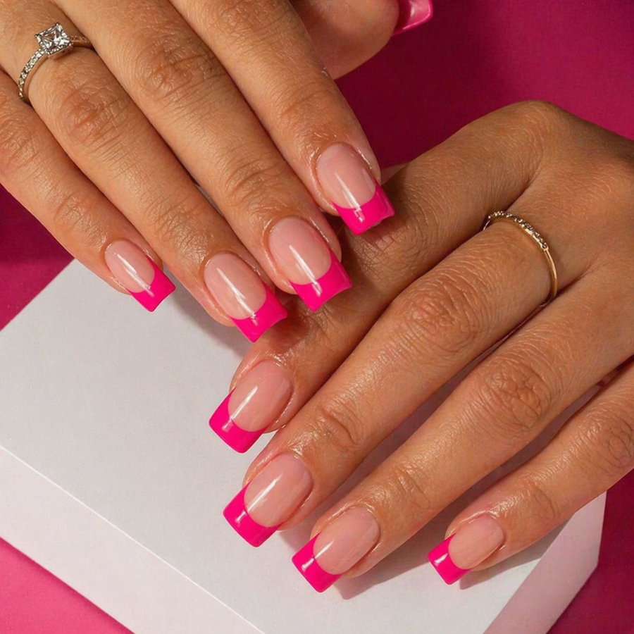 Square nails with bold hot pink French tips on a nude base featuring a sharp straight edge and high contrast glossy finish