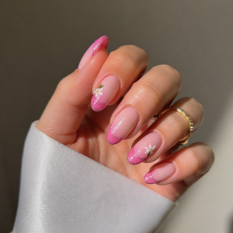 Pink ombre French tip nails with soft gradient blend and delicate white floral nail art on almond nails