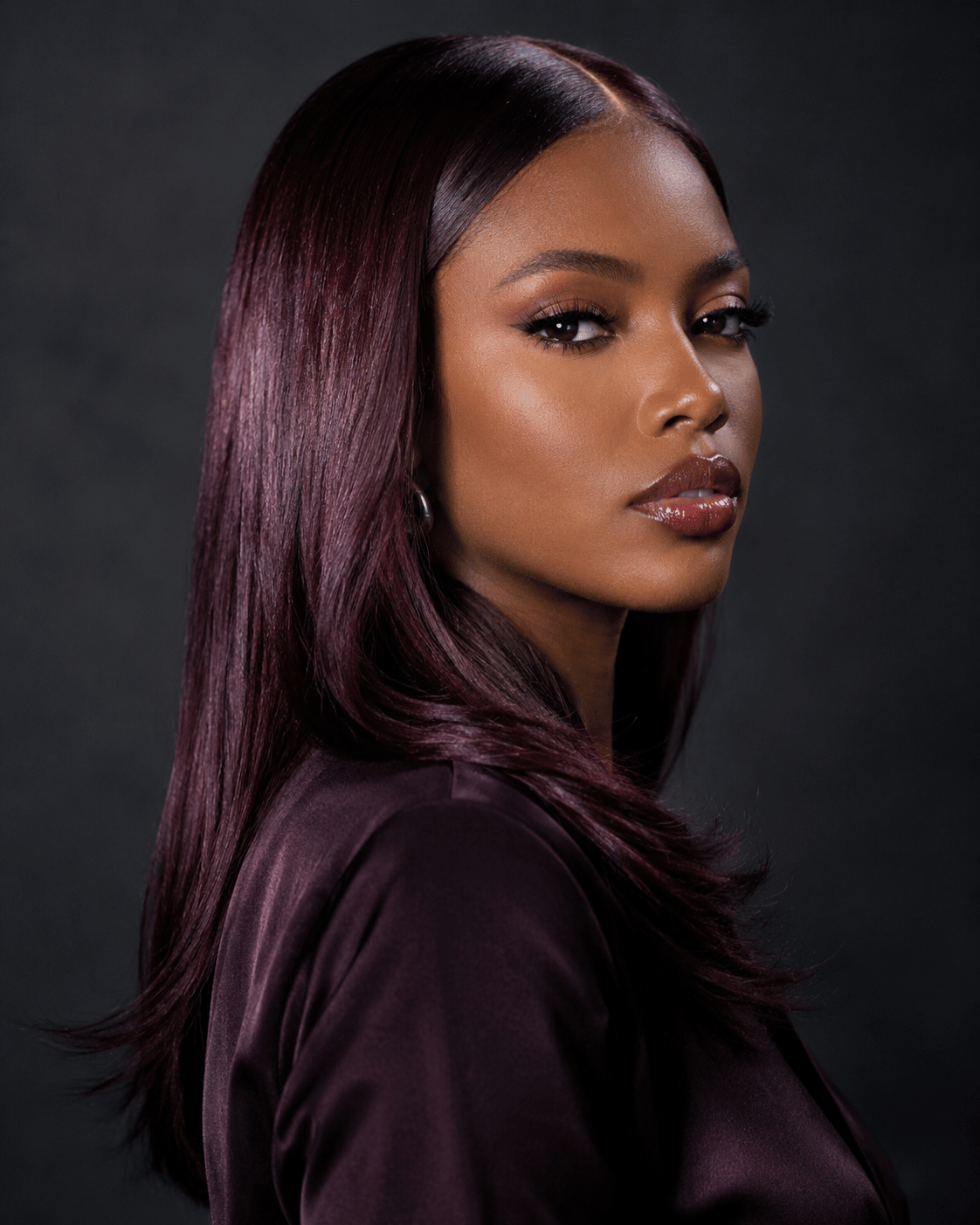 Burgundy hair color on deep dark skin with sleek straight styling and cool wine-red undertones