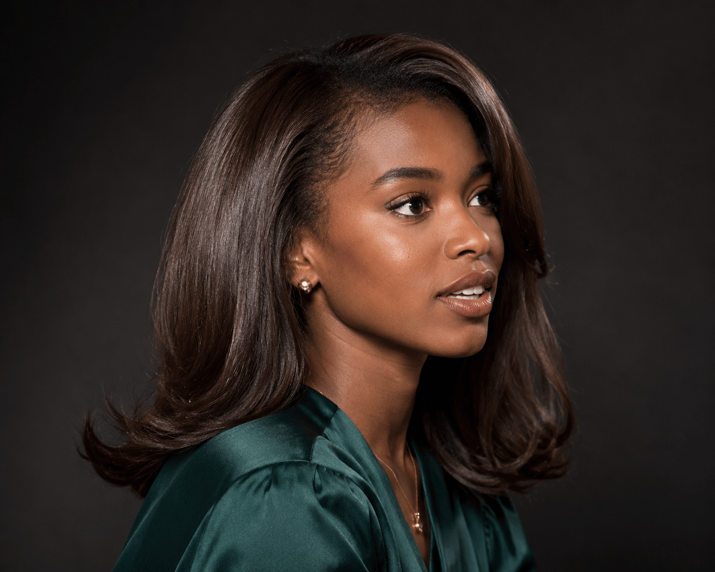 Glossy chocolate brown hair color on dark skin with smooth blown-out hairstyle and reflective shine