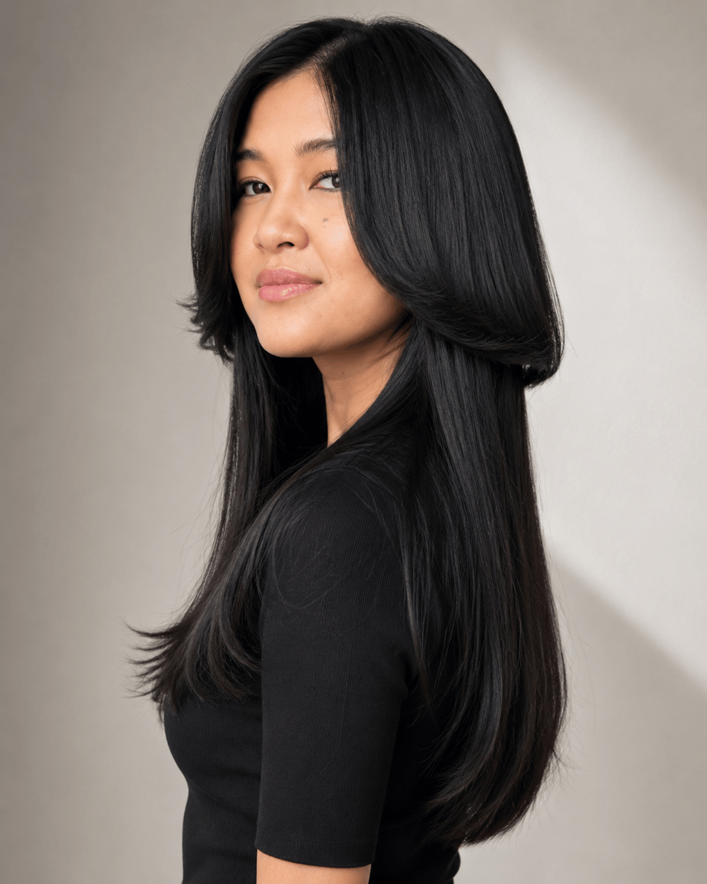 Jellyfish cut on straight hair showing sharp disconnected layers with a rounded upper section and sleek long lower layer