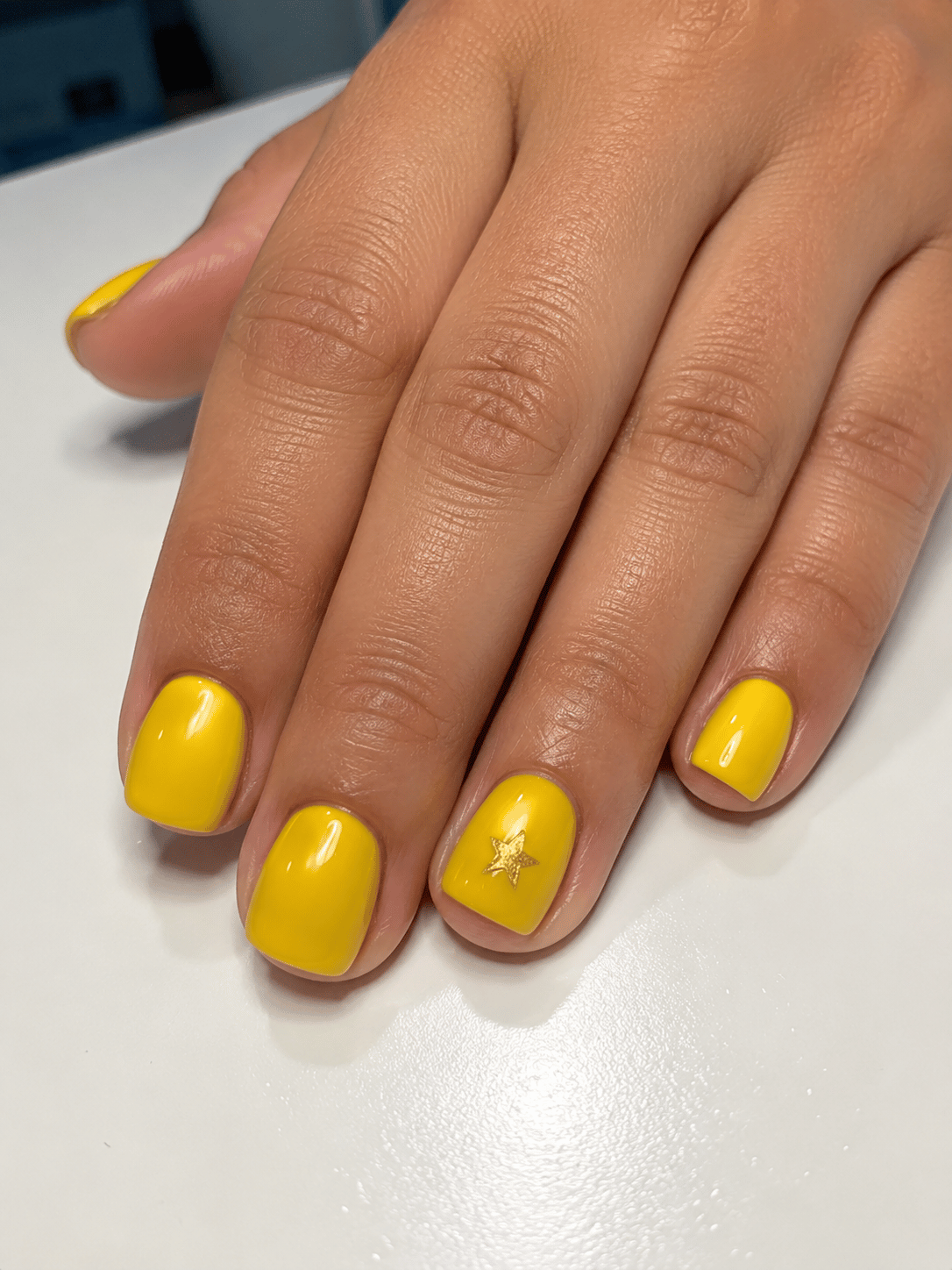 Brazil championship star nails with glossy yellow square manicure and single gold star accent