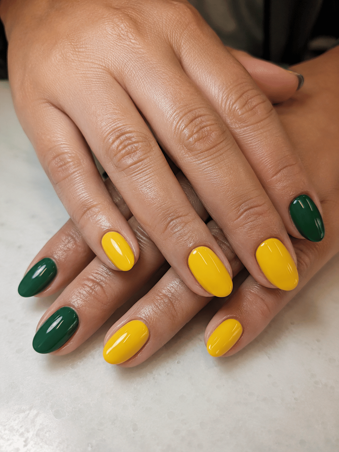 Brazil football nail art with soccer ball accent nail and Brazilian flag detail on glossy green and nude manicure