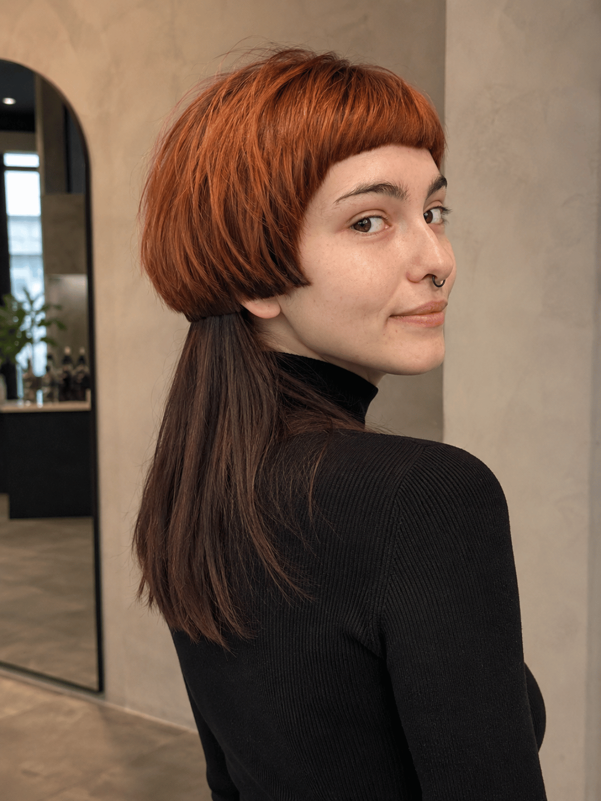 Two-tone jellyfish haircut featuring a copper top layer and brunette bottom layer with a clean color block separation between the disconnected sections.