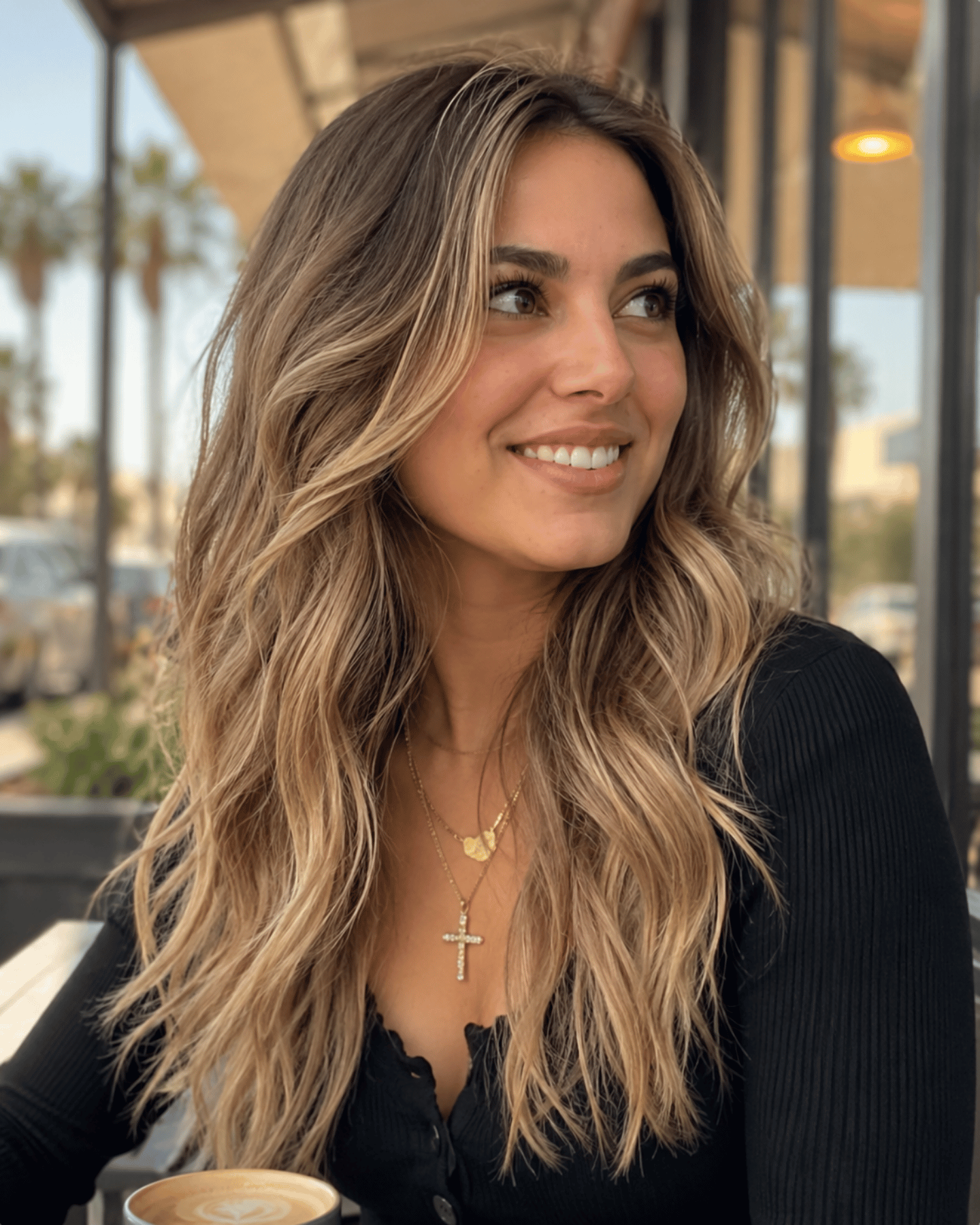 Medium sandy blonde hair with natural balayage showing balanced warm and cool blonde tones on soft wavy hair
