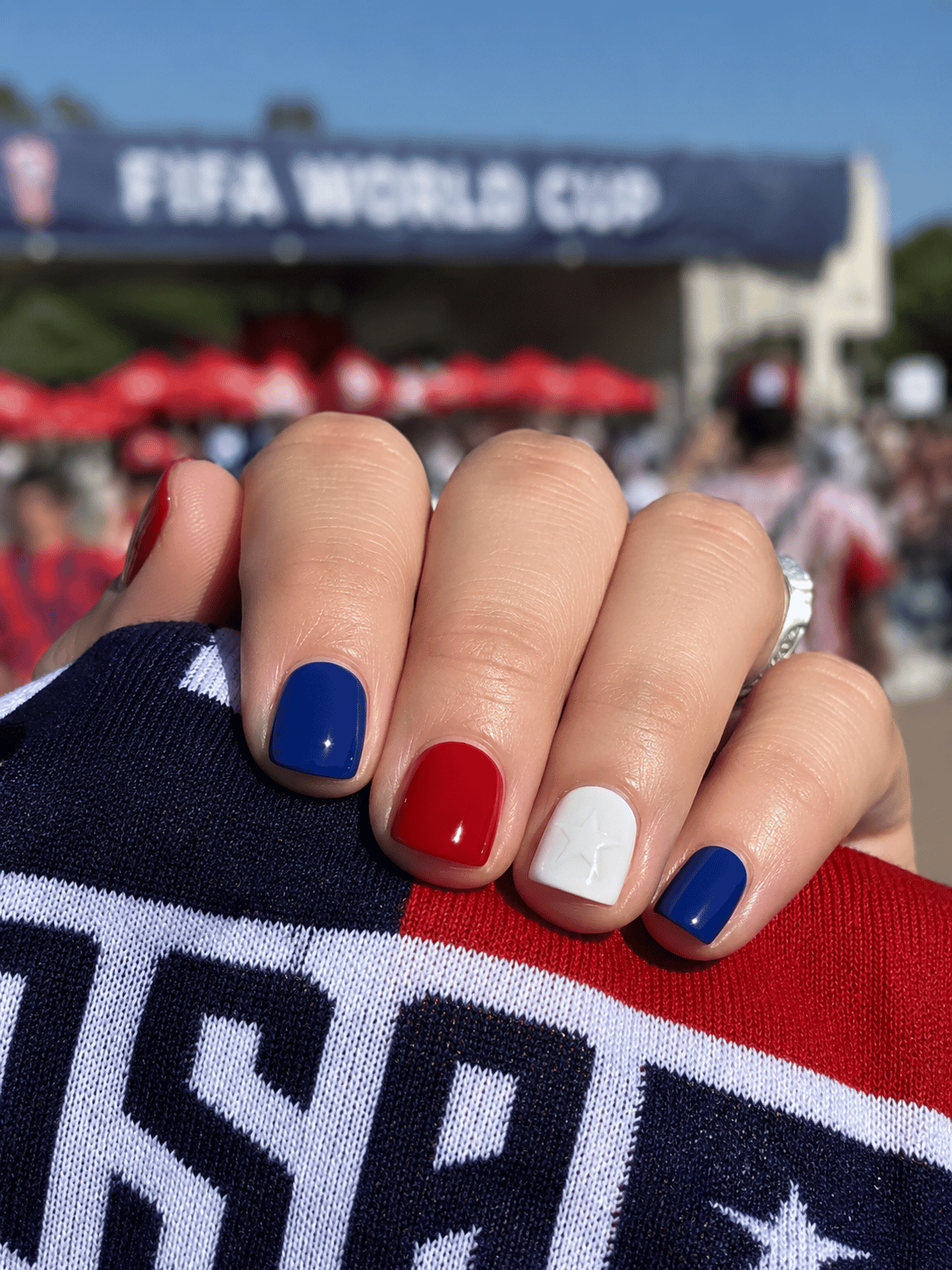 Red white and blue USA soccer nails with deep cobalt blue polish, bold red accents and white star detail on short square nails