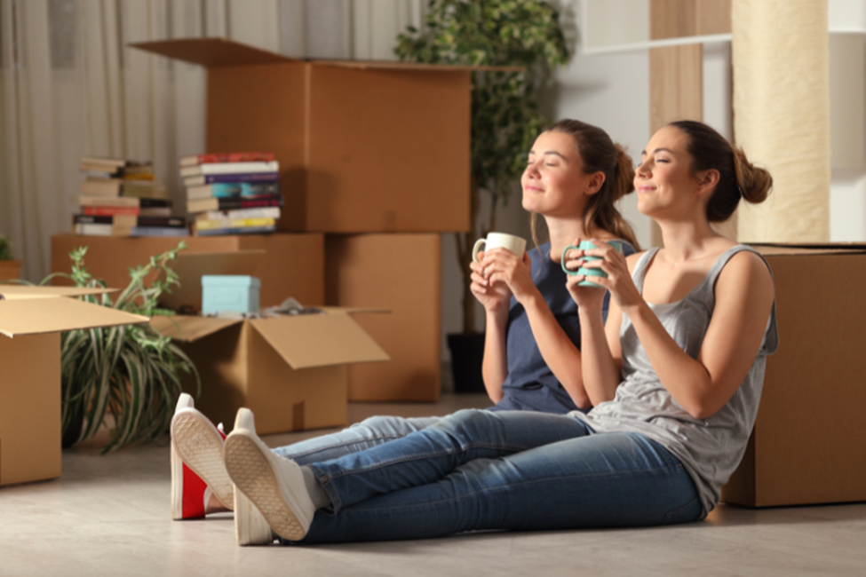 Happy roommates relaxing in their new home after moving, enjoying a fresh start and a comfortable living space.