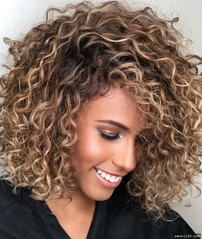 Bronde hair color on natural curly hair showing dimensional highlights