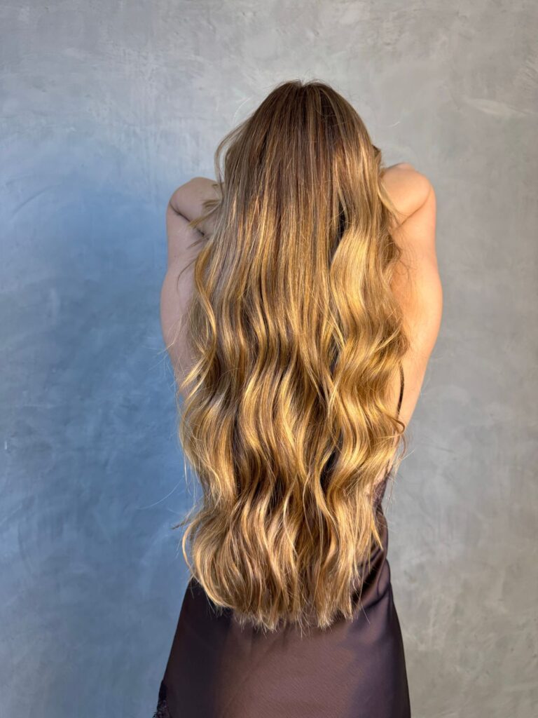 Caramel balayage on long brunette hair with textured waves