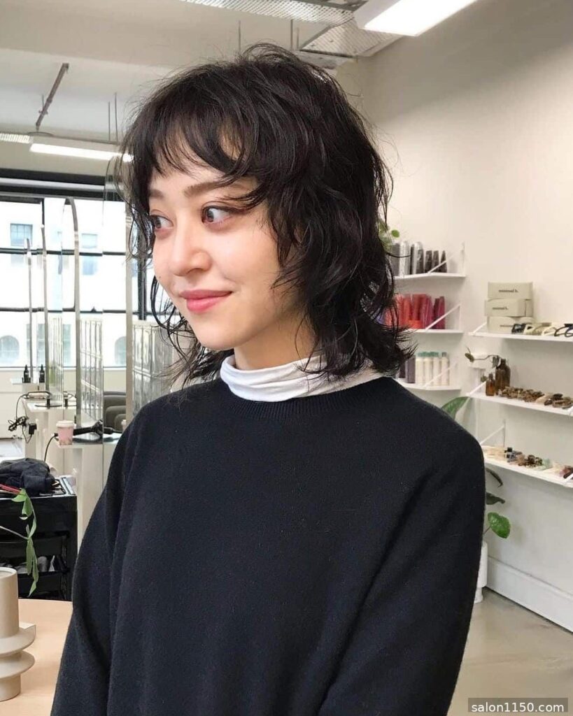 Medium wolf cut with soft bangs framing the face in a salon